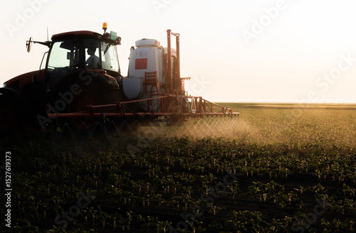 Tractor spraying soybean crops field