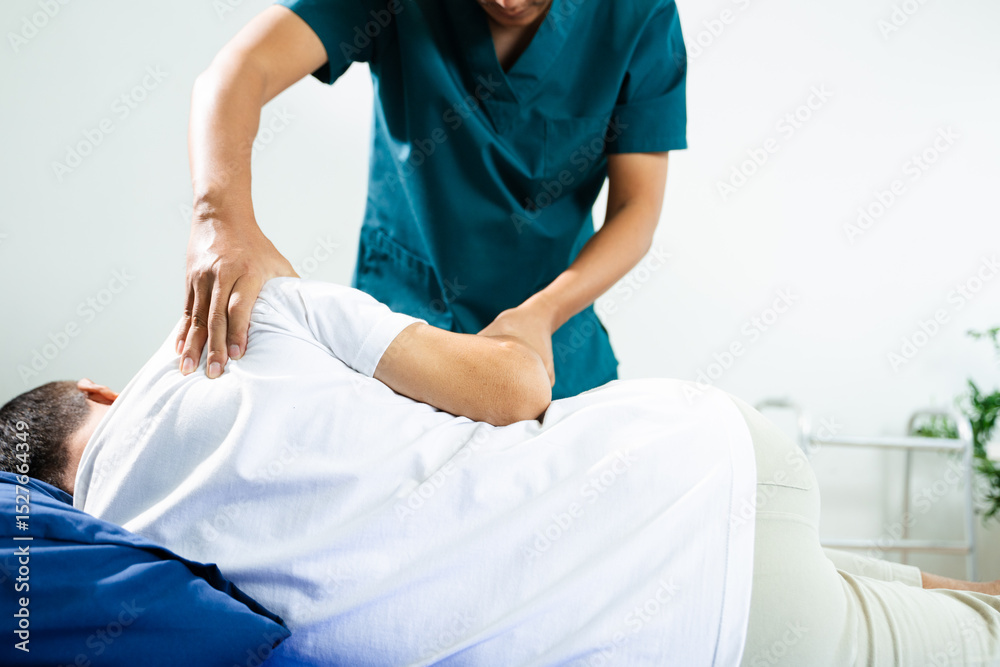 Obraz premium Male physiotherapist applies manual therapy on patient's back during rehab session. Spine care, posture alignment, and muscle relief