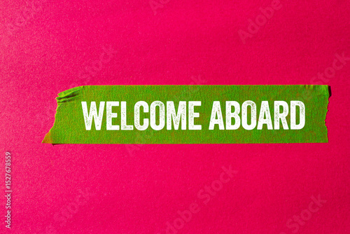 Welcome aboard message written on ripped torn green paper tape on pink background. Conceptual welcome aboard symbol. Copy space.