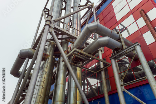 Large industrial building with a lot of pipes and a lot of windows. The building is red and blue