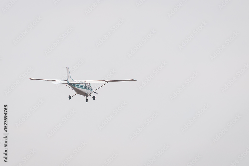 Private Airplane in Flight – Small Aircraft Landing or Taking Off in a Cloudy Blue Sky Private Airplane in Flight – Small Aircraft Landing or Taking Off in a Cloudy Blue Sky
