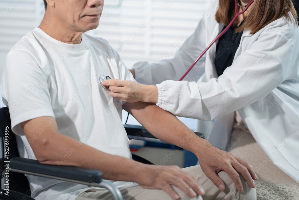 Obraz premium Doctor with stethoscope examining elderly patient sitting in a wheelchair with examination, recommending treatment, healthcare and medical concept.