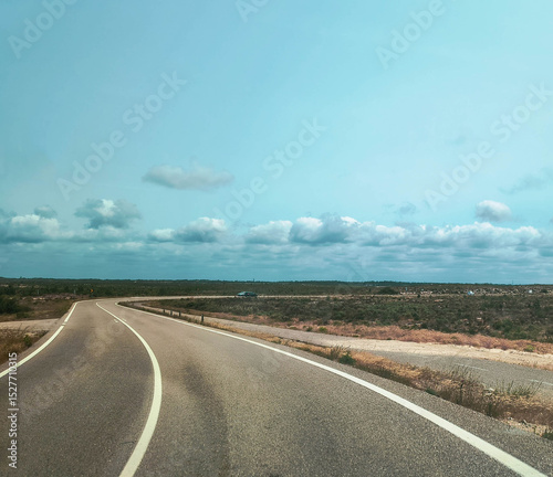 Open road under a cloudy sky. Serene landscape ideal for travel blogs, transportation themes or representing journeys. Perspective invites exploration  adventure. photo