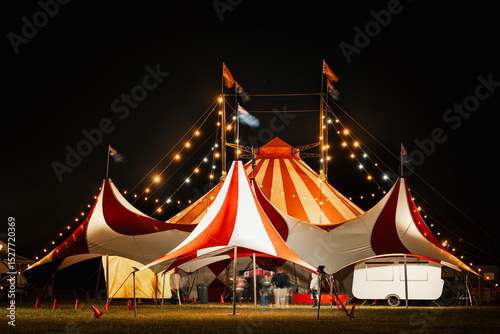 Motion blur people outside big top circus tent at night