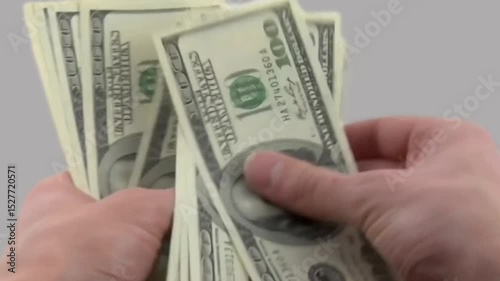 man's hand counting dollar bills isolated in gray