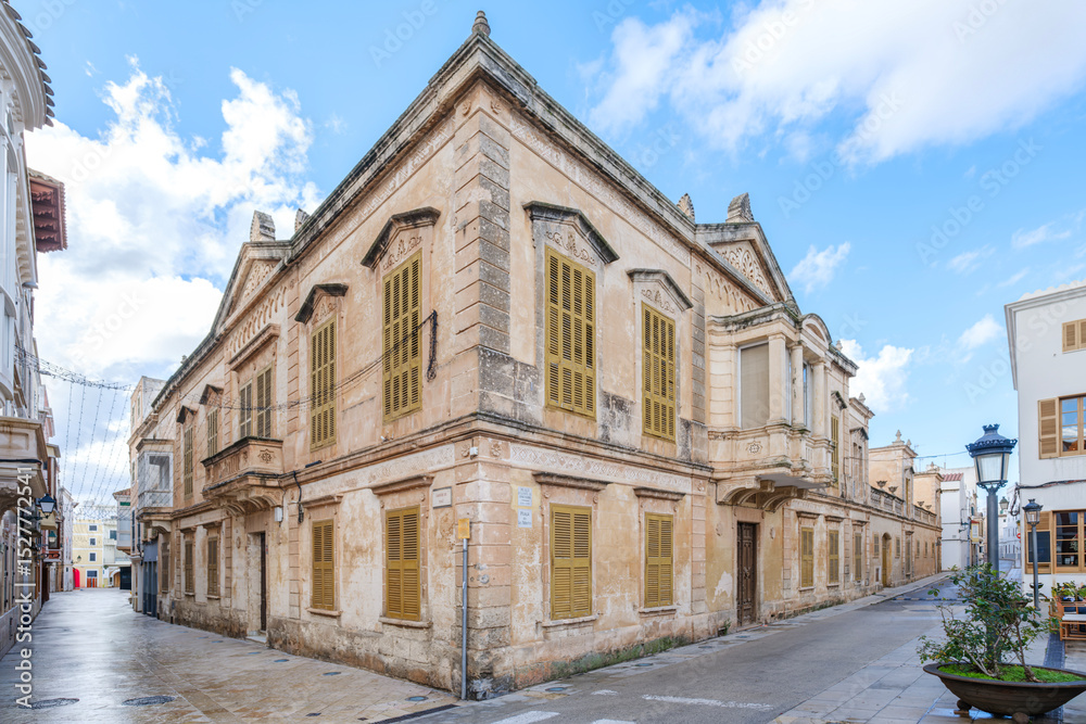 Fototapeta premium Historic Stone Building on a Corner Street in Ciutadella de Menorca. Traditional Spanish architecture, charming urban landscape, Mediterranean island, travel destination