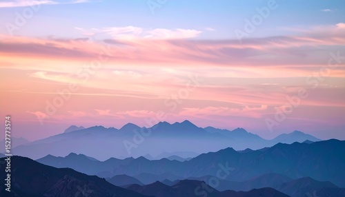 Dreamy cotton-candy sky with pearlescent clouds above a blurred silhouette of soft mountains at dusk