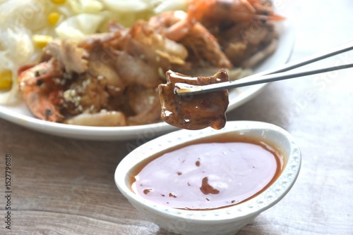 Korean fried slice pork with cabbage and glass noodles on plate dipping spicy sauce couple soup