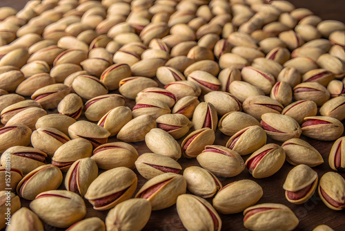Scattered pistachio nuts on dark background