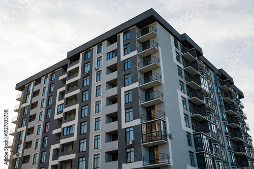 Modern architecture showcases urban living in a newly constructed apartment building against a cloudy sky during late afternoon