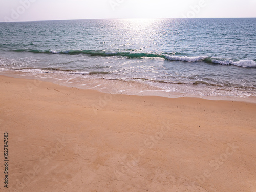 Top view beach with waves crashing on sandy shore,Beautiful waves sea surface in summer seascape background,Amazing beach colorful water background