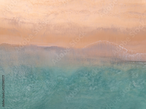 Top view beach with waves crashing on sandy shore,Beautiful waves sea surface in summer seascape background,Amazing beach colorful water background