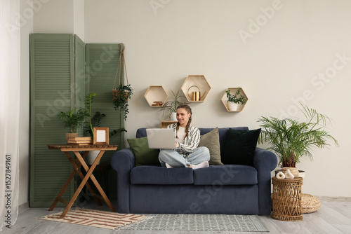 Young woman sitting on blue...