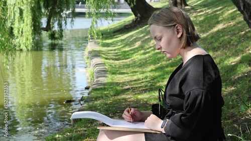 The young woman sketching a floral composition with a pencil during a plein air session