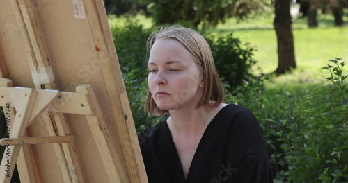 The young woman sketching a floral composition with a pencil during a plein air session