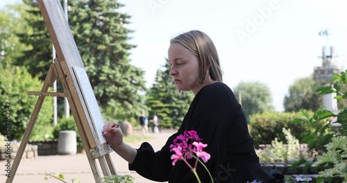 The young woman sketching a floral composition with a pencil during a plein air session