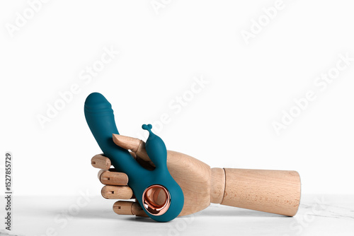 Wooden hand with vibrator on white table