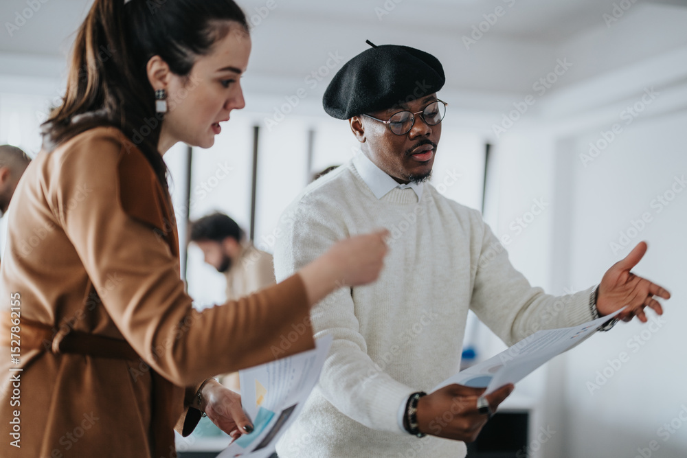 Obraz premium Two coworkers engage in a discussion, collaborating on documents during a business meeting in a modern workspace, showcasing teamwork and professional interaction.