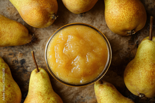 Jar of golden pear jam surrounded by fresh ripe pears on rustic surface, styled with soft natural light and warm tones