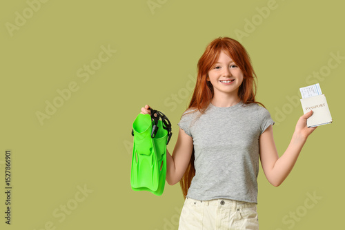 Cute girl with flippers and passport on green background. Travel concept
