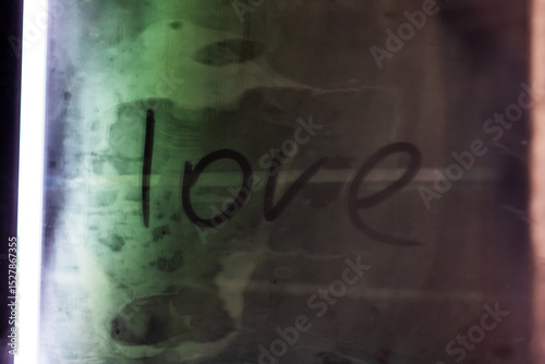 The word love is beautifully written on a green and black background