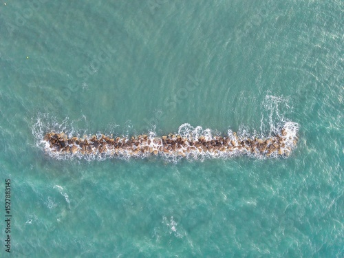 Aerial View of Coastal Rock Formation Above Turquoise Sea