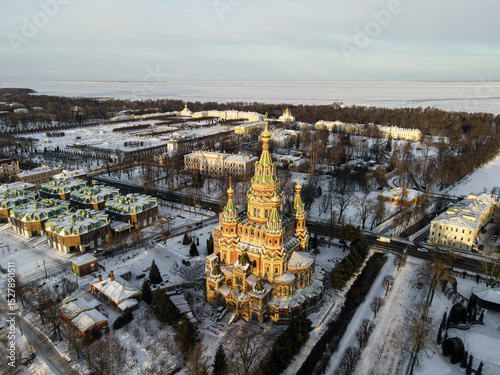 An aerial view features the Peter and Paul Cathedral in Peterhof, with the frozen Gulf of Finland visible in the background