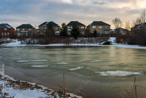 Frozen pond in snowy landscape scene during winter in Ancsater, Hamilton, Ontario, Canada.