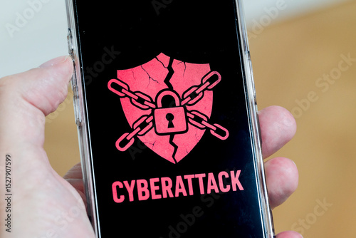 Hand holding phone with cyberattack alert screen