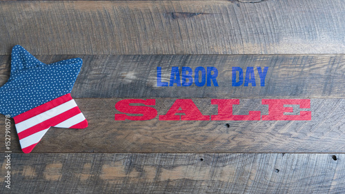 Labor Day Sale text with red, white, and blue, star shape on wooden background banner.