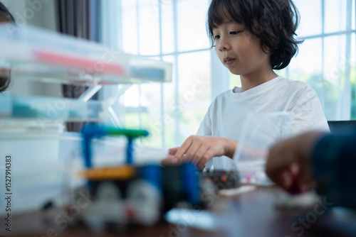 Young Engineers: multi ethnic Children engrossed in building and testing small robotics, showcasing curiosity, teamwork, and early STEM education. The focus robot and children hands-on engagement.