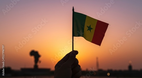Senegal pride a hand holds the Senegalese flag against a vibrant sunset, symbol of national identity and patriotism