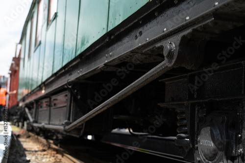 Rail car mechanism reveals intricate details at a vintage train exhibition during a sunny afternoon