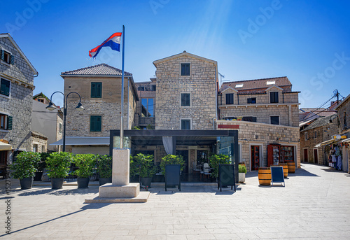 Fototapeta Naklejka Na Ścianę i Meble -  Peaceful village street in Primosten, Croatia, featuring a small stone chapel, historical architecture, and Mediterranean charm.