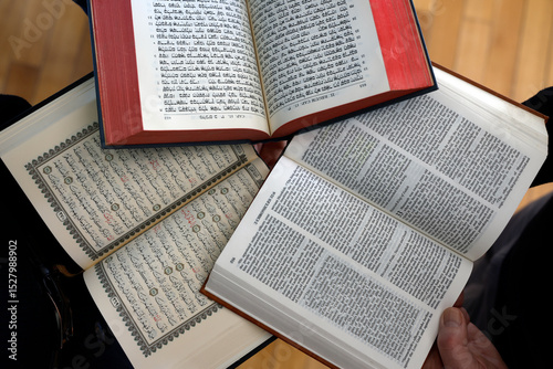 Three monotheistic religions. A Christian, a Jew, and a Muslim reading the Bible, the Torah, and the Quran. Symbol of peace and interfaith dialogue. photo