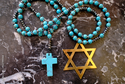 Two monotheistic religions, Christianity and Judaism. A rosary and a star of David.  Religious symbols. photo