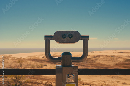 Observation deck with fixed observation binoculars. View on a sand dune and seashore