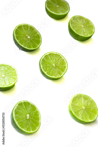 Vibrant green lime halves arranged on a clean white surface. The juicy texture and vivid color evoke a sense of freshness, summer, and natural simplicity. Selective focus.