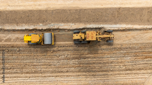 Aerial view motor grader civil at construction site, Motor grader work on construction site, Road grader on road construction site machine work on the construction of new road.