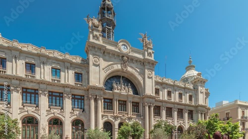 Historic Post Office (Palau de les Comunicacions) in Valencia timelapse hyperlapse at City Hall Square (Plaza del Ayuntamiento). Ornate facade, traffic and a blue sky in the Spanish city center.