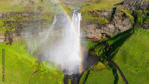 The stunning Seljalandsfoss Waterfall in Iceland, highlighted by a beautiful rainbow