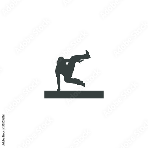 Silhouette of a breakdancer performing a floor move over an obstacle