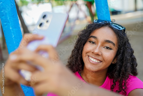 Young woman taking a selfie with smartphone in a park