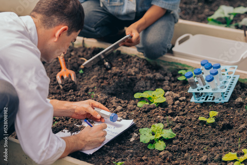 Φωτογραφία Multiracial students conducting farming and environmental research inside greenhouse laboratory