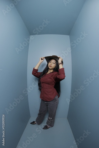 Woman in a cowboy hat lying in a blue room