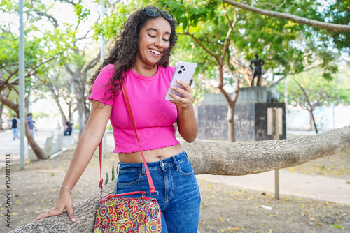 Young latin woman using mobile phone in a park in Guayaquil, Ecuador