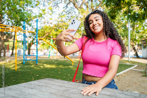 Young woman taking a selfie with smartphone in a playground