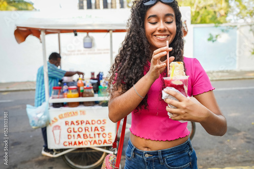 Young woman enjoying a raspado from a street vendor in Guayaquil, Ecuador