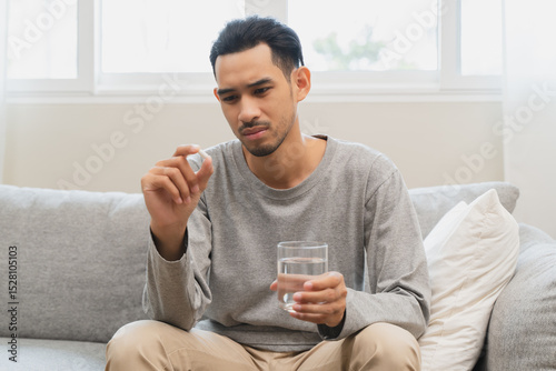 Close-up a medicine tablet in young man hand taking painkiller