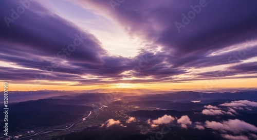 Majestic cloudscape over mountain range illuminated by golden dawn light